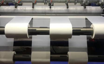 A machine is cutting nylon mesh fabrics into ribbon.