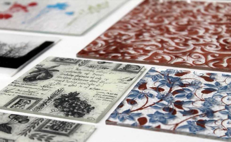 Several screen printed glass pieces with colorful patterns on the table.