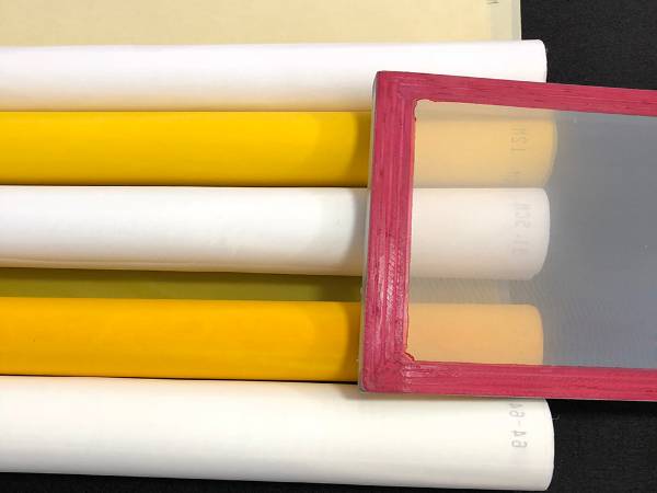 A stencil on several rolls of polyester screen printing mesh.